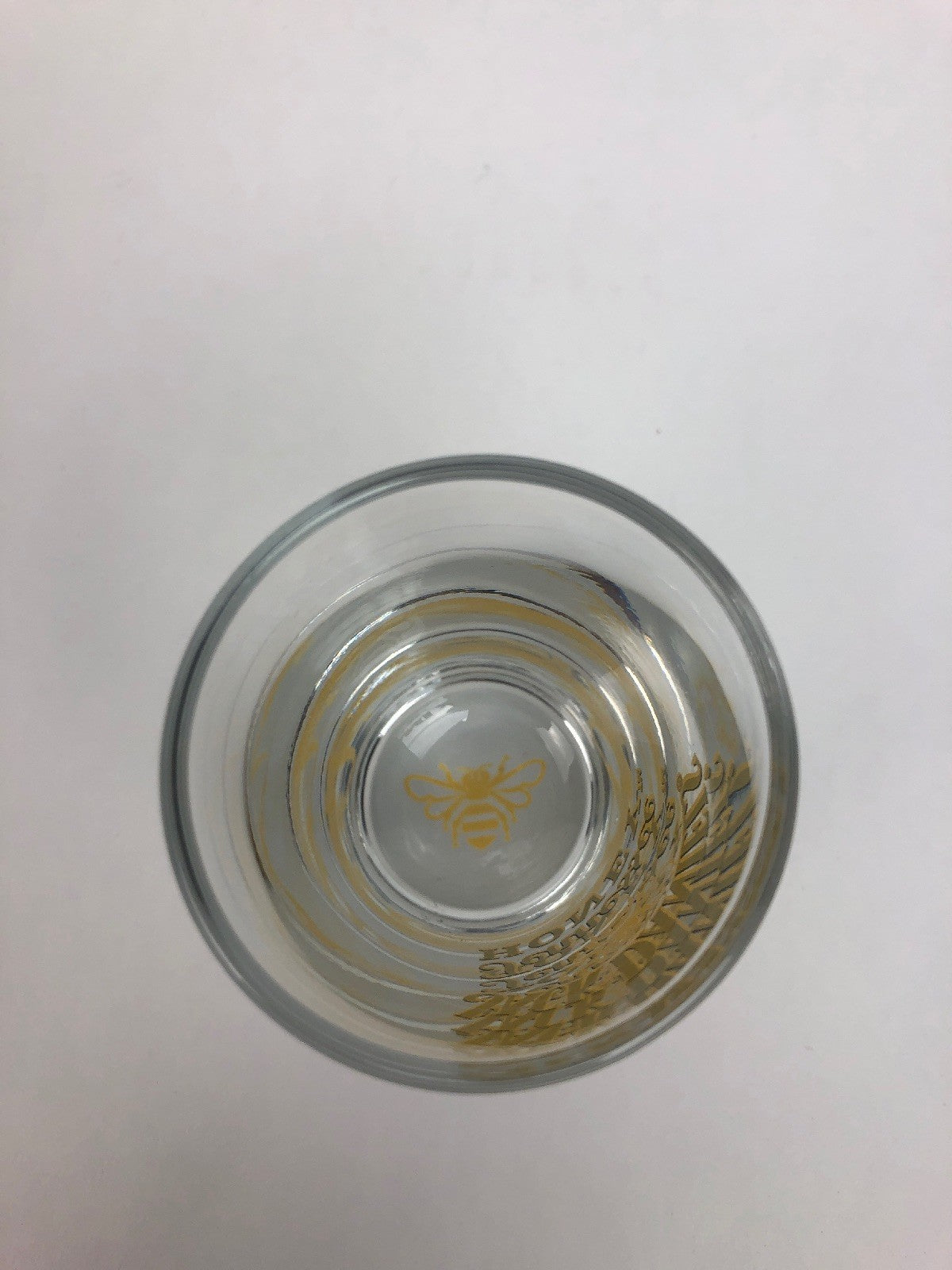 Jack Daniel's Tennessee Honey clear shot glass with gold honey bee design.