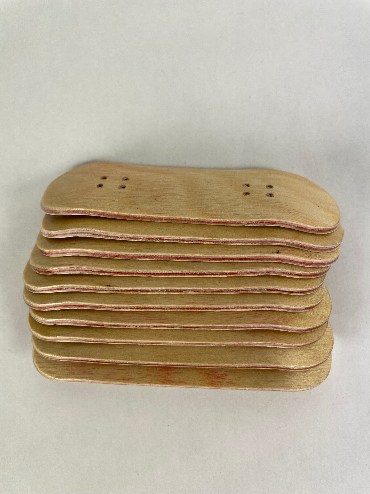 Lot of 10 wooden fingerboard mini skateboards with natural wood grain finish for fingerboarding, crafts, and customization.