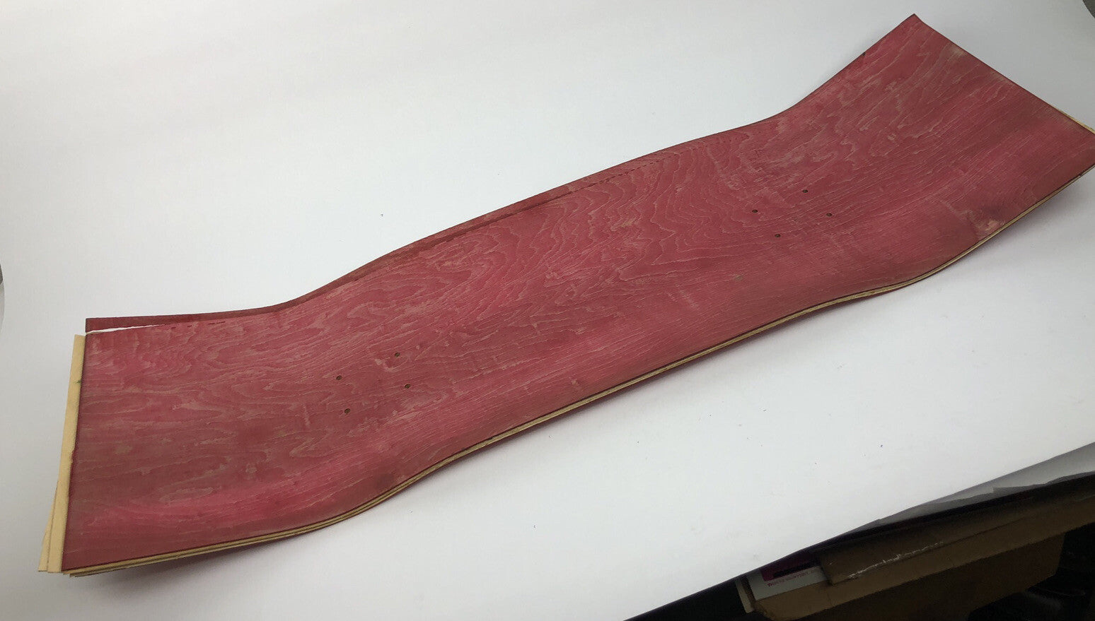 Blank uncut red stain skateboard deck 10 x 34 inches with 14.25-inch pre-drilled wheelbase.