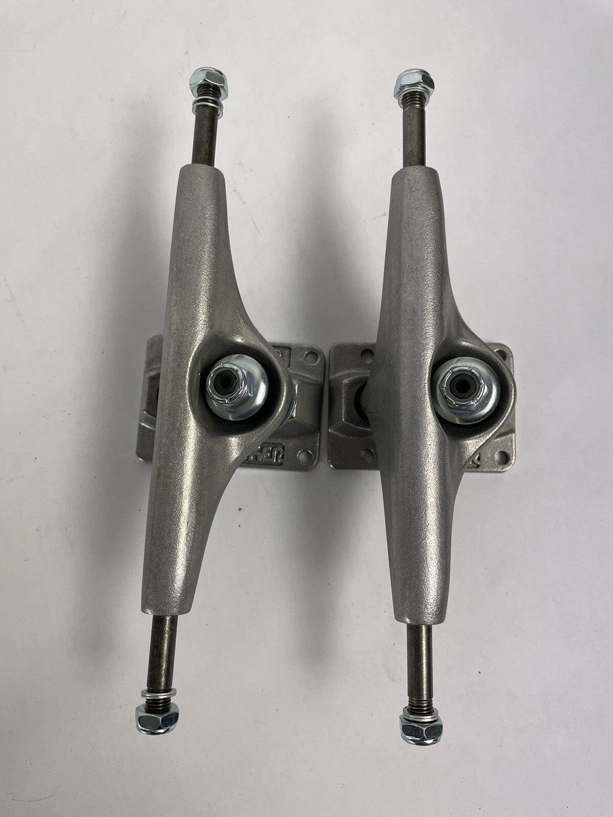 Pair of Tracker Axis 139mm polished skateboard trucks with 8.25-inch axle width and hollow kingpin for street and park skating.