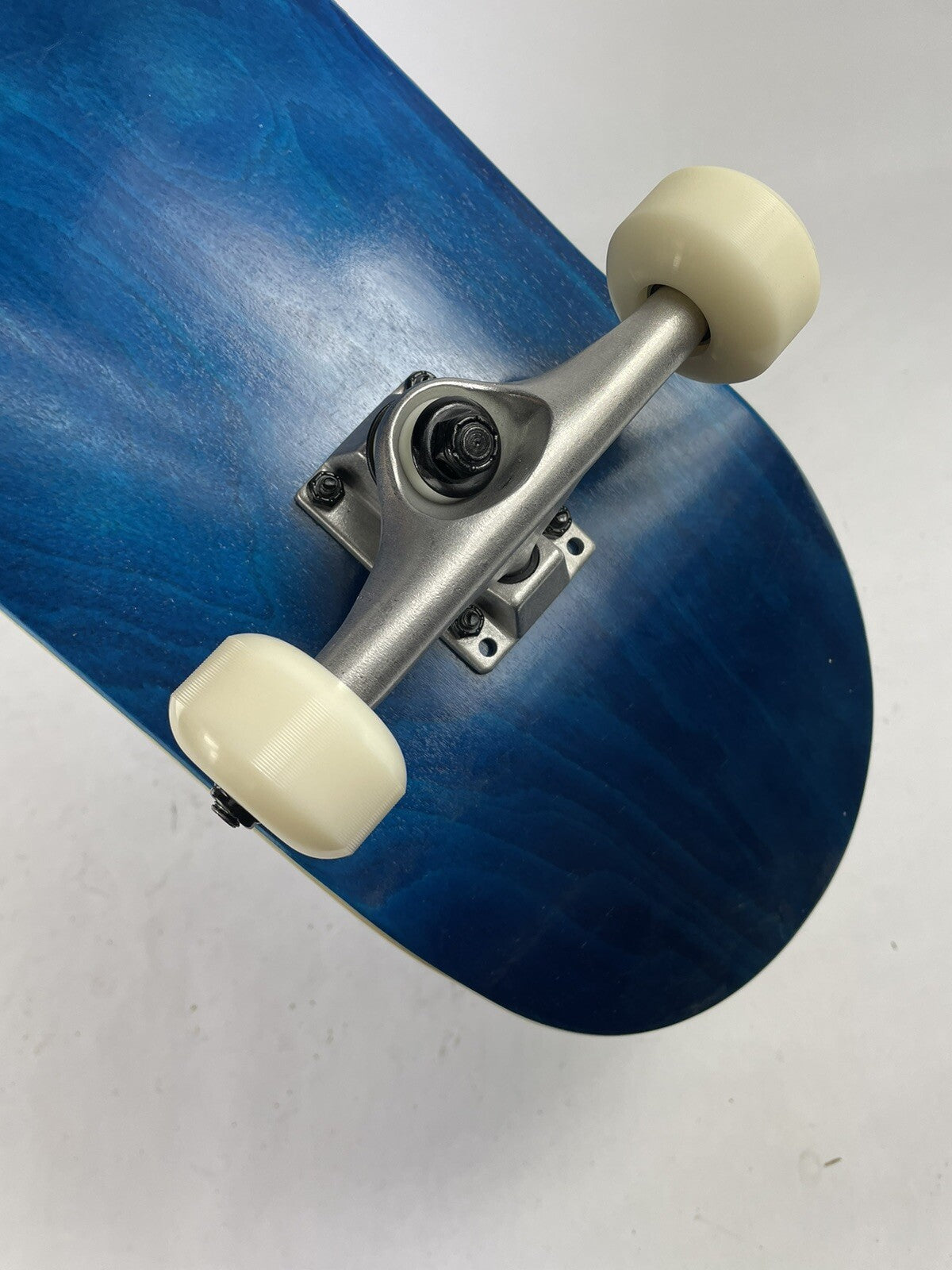 Blue blank 8-inch complete skateboard with gravity cast trucks, 52mm ATM wheels, and ABEC 7 bearings.
