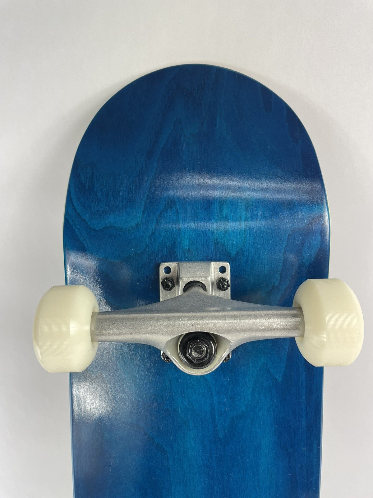 Blue blank 8-inch complete skateboard with gravity cast trucks, 52mm ATM wheels, and ABEC 7 bearings.