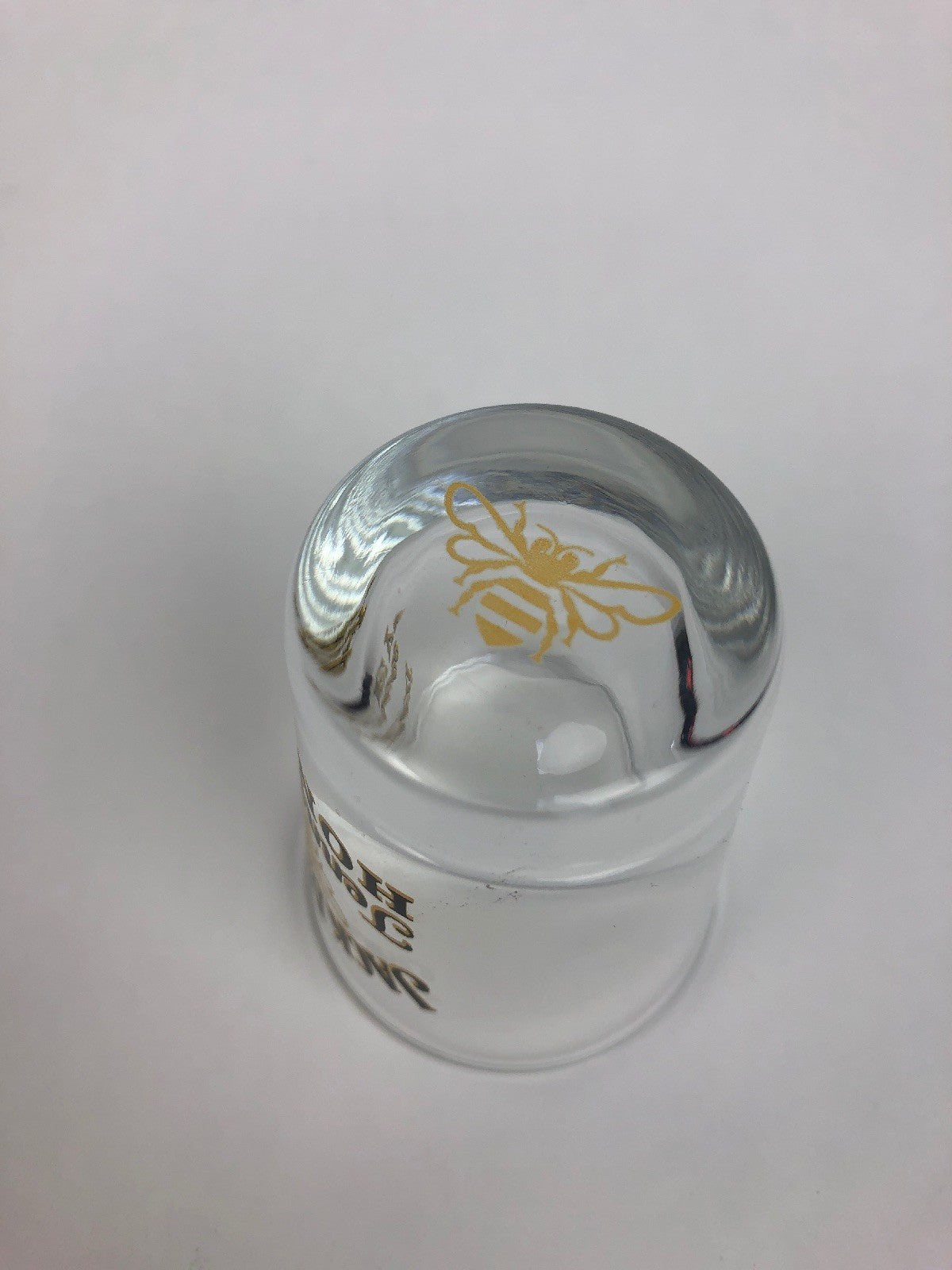 Jack Daniel's Tennessee Honey clear shot glass with gold honey bee design.