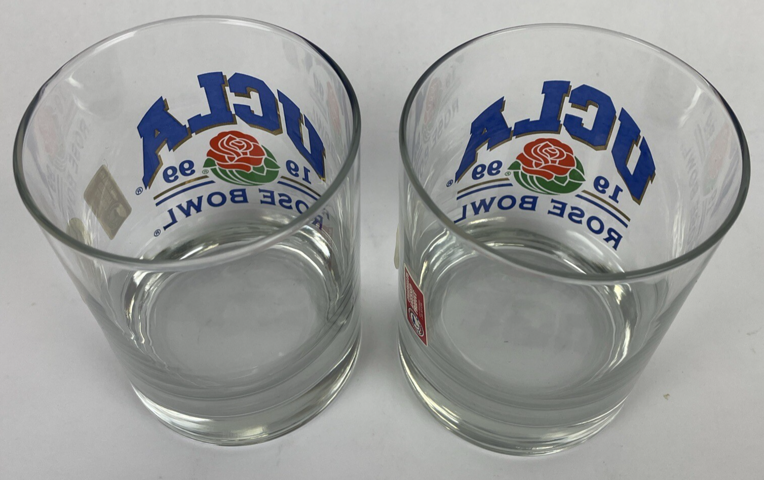 Set of two vintage UCLA Rose Bowl 1999 blue print bar glasses with gold trim.