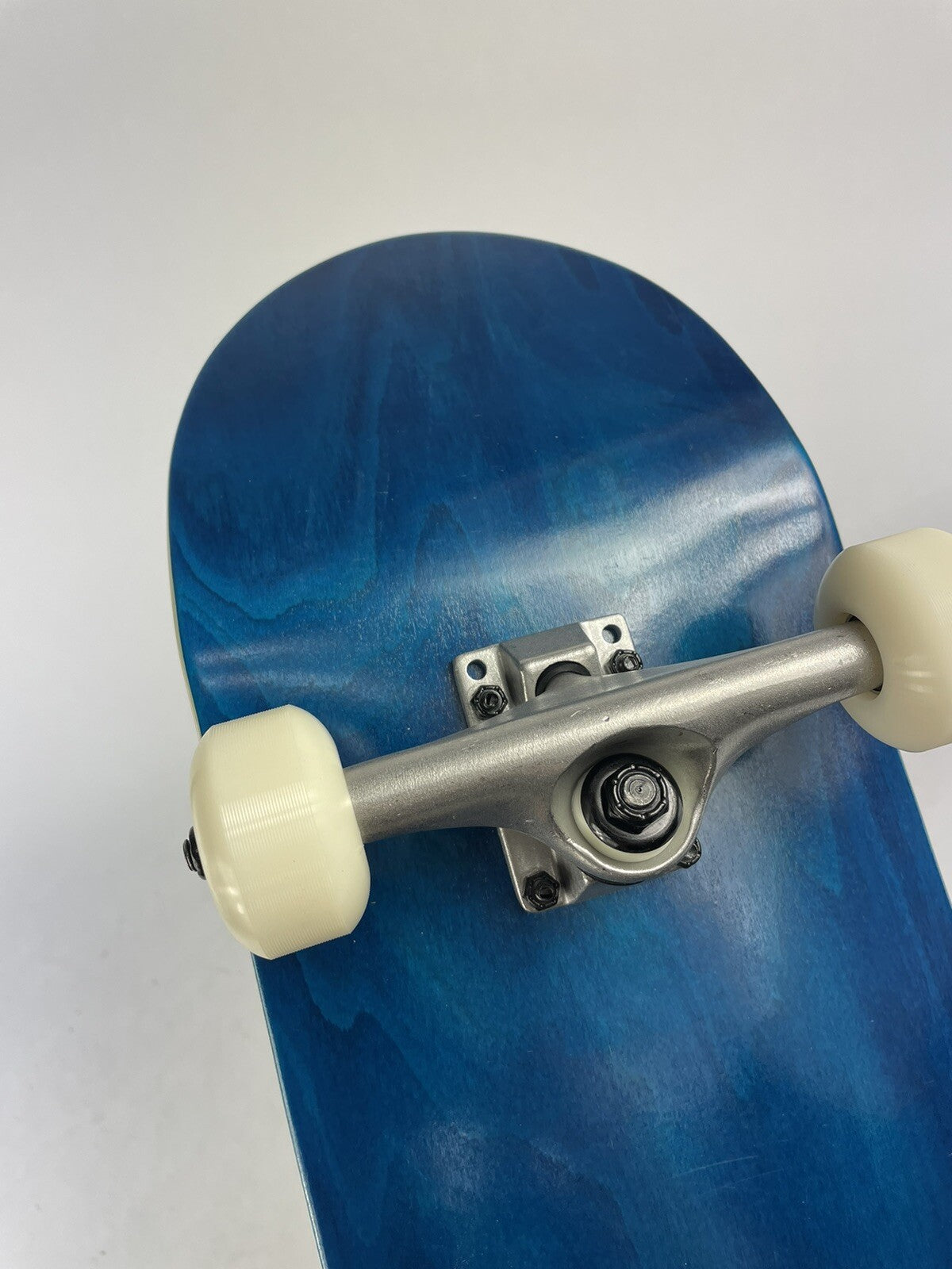 Blue blank 8-inch complete skateboard with gravity cast trucks, 52mm ATM wheels, and ABEC 7 bearings.