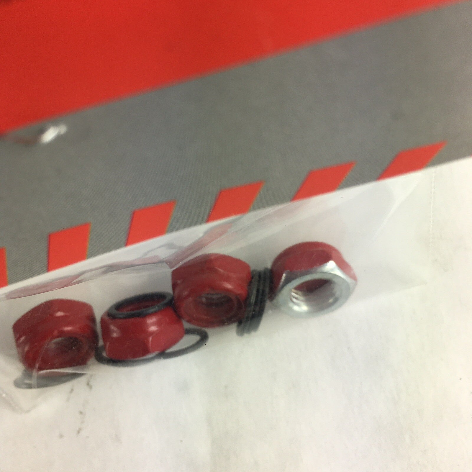 Grind King red skateboard truck axle lock nuts with washers and speed rings hardware set.