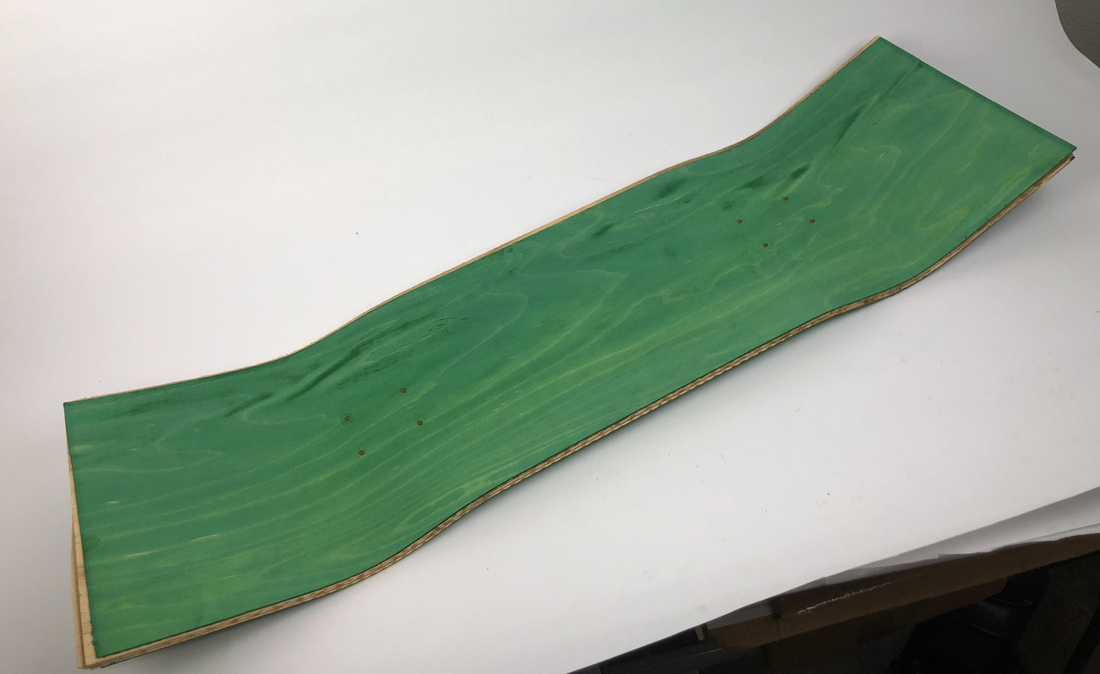 Blank uncut 10 x 34-inch green stain skateboard deck with 14.25-inch wheelbase.