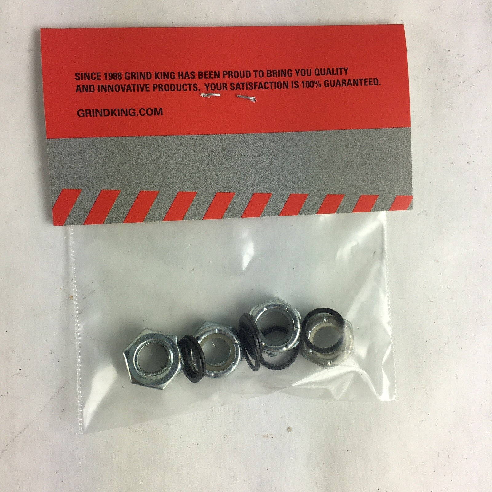 Grind King skateboard truck axle hardware kit with lock nuts, washers, and speed rings for truck maintenance and wheel installation.
