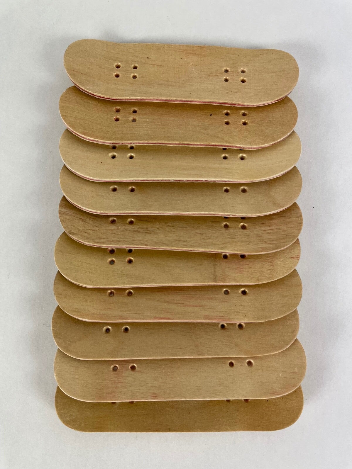 Lot of 10 wooden fingerboard mini skateboards with natural wood grain finish for fingerboarding, crafts, and customization.