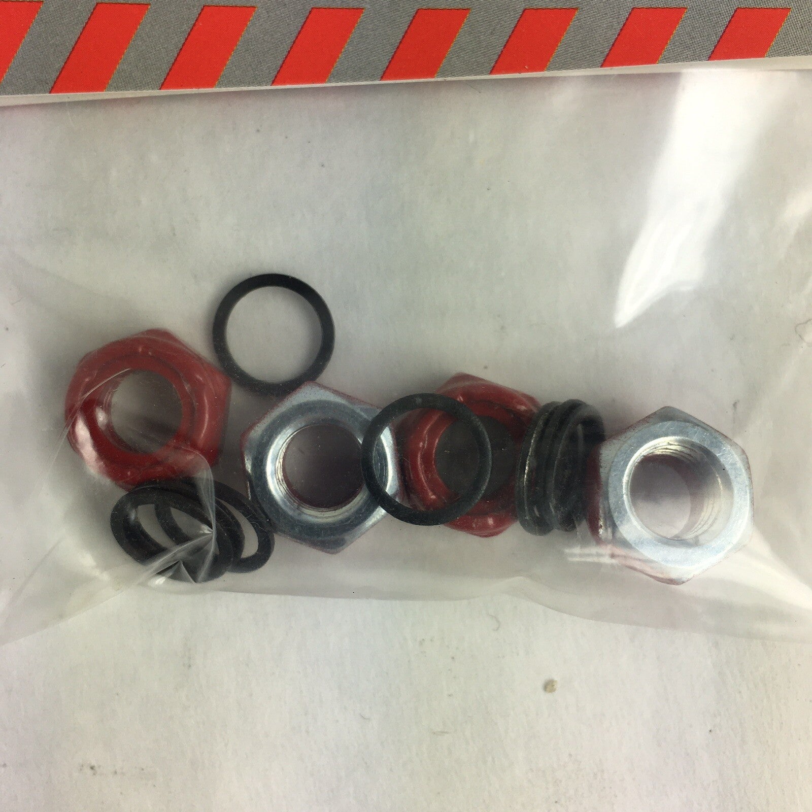 Grind King red skateboard truck axle lock nuts with washers and speed rings hardware set.