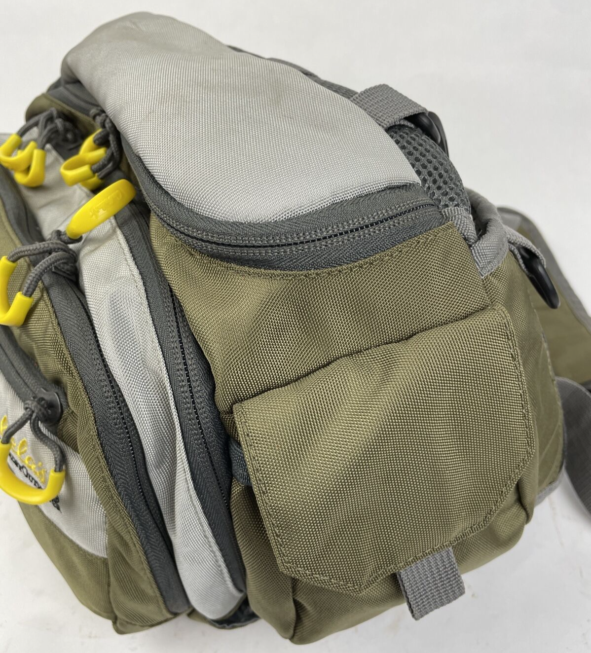 Cabela's Advanced Anglers green waist pack with extras for fly fishing and hiking.