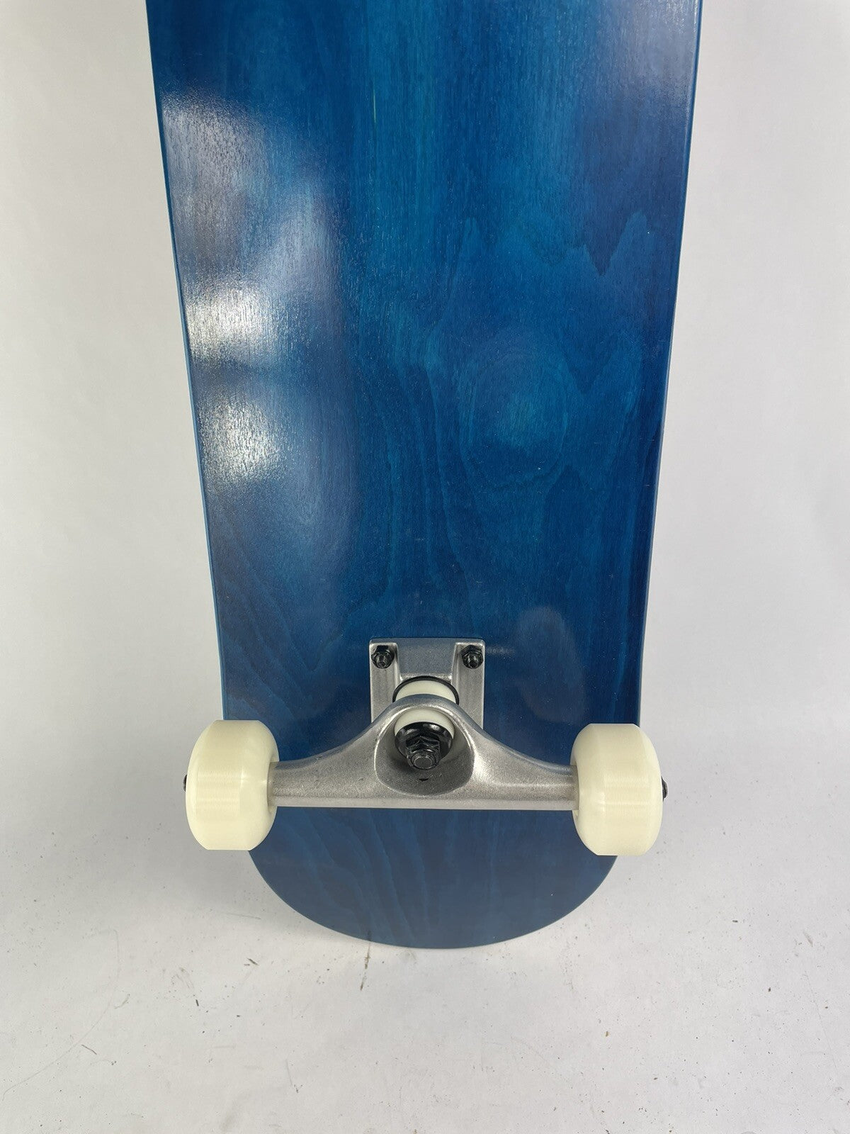 Blue blank 8-inch complete skateboard with gravity cast trucks, 52mm ATM wheels, and ABEC 7 bearings.