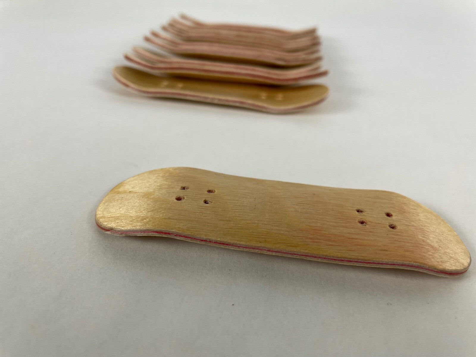 Lot of 10 wooden fingerboard mini skateboards with natural wood grain finish for fingerboarding, crafts, and customization.