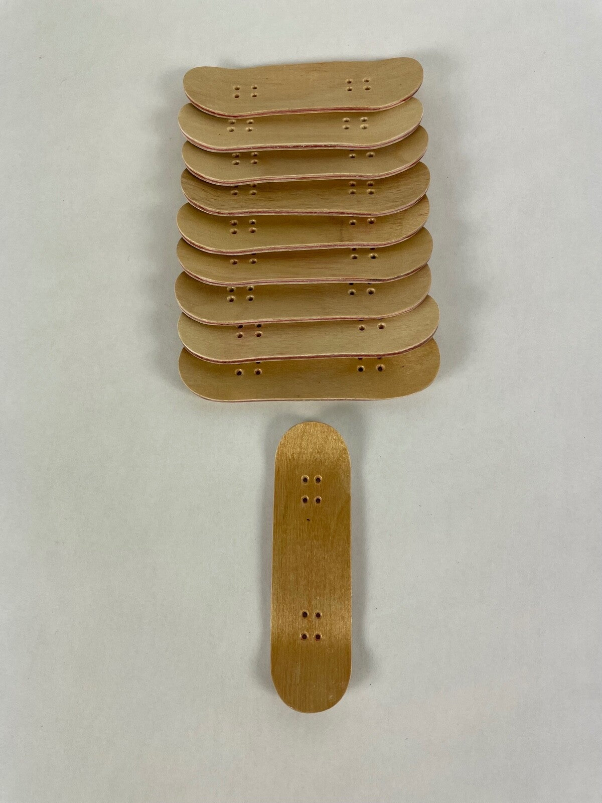 Lot of 10 wooden fingerboard mini skateboards with natural wood grain finish for fingerboarding, crafts, and customization.