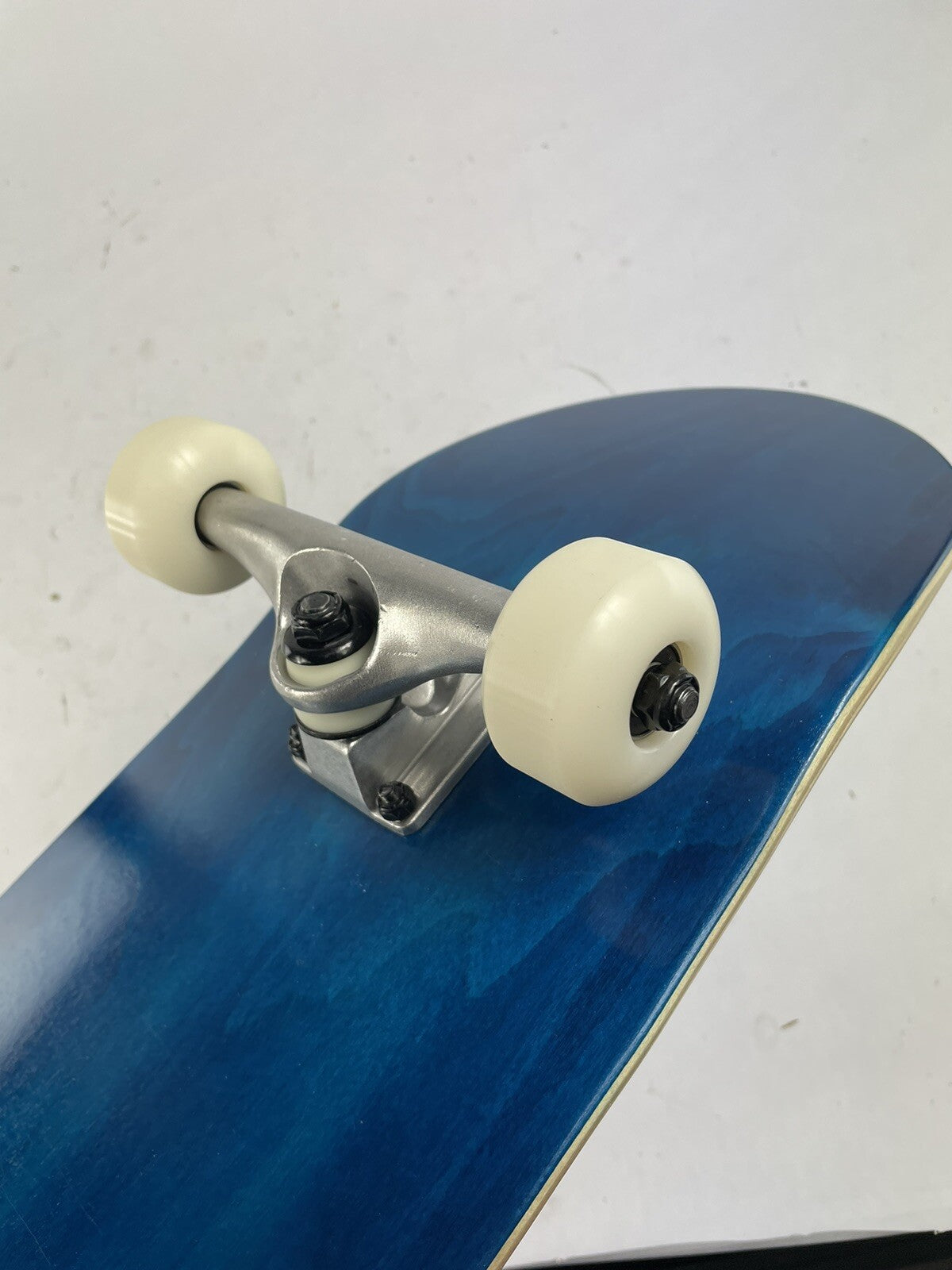 Blue blank 8-inch complete skateboard with gravity cast trucks, 52mm ATM wheels, and ABEC 7 bearings.