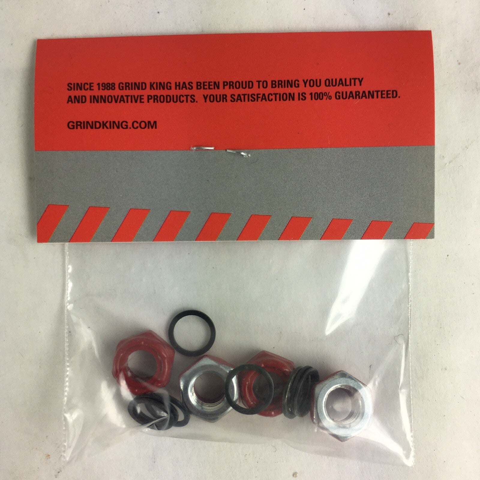 Grind King red skateboard truck axle lock nuts with washers and speed rings hardware set.