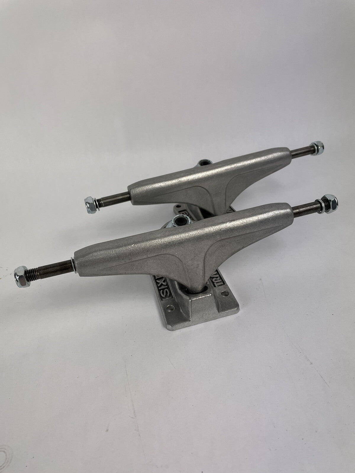Tracker Axis polished skateboard trucks with 129mm axle, 5.0-inch hanger, and hollow kingpin for lightweight performance.
